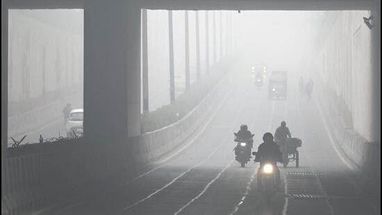 Commuters out on a foggy morning in Noida on Monday. (Sunil Ghosh/HT Photo)