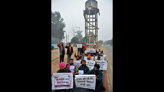 Physical education teachers staging a protest over their demand for regular jobs in Mohali on Monday. (HT Photo)