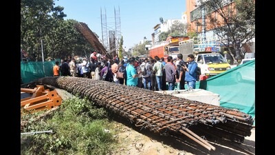 People gather at the accident site where a half broken iron structure of a metro pillar fell, at Hennur Main Road in Bengaluru on Tuesday. (PTI) People gather at the accident site where a half broken iron structure of a metro pillar fell, at Hennur Main Road in Bengaluru on Tuesday. (PTI)