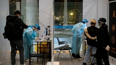 Covid In China: Workers wearing protective suits stand in a booths to take Covid-19 tests. (AP) Covid In China: Workers wearing protective suits stand in a booths to take Covid-19 tests. (AP)