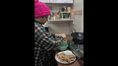 Desi mom making pakoras in the kitchen and convincing her son to eat them. (Instagram/@kapoorss2)
