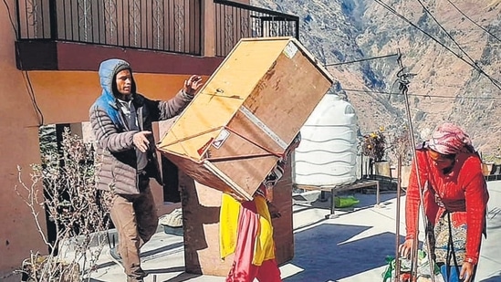 Local residents evacuate a building in Joshimath area of Uttarakhand’s Chamoli district on Tuesday. (PTI) Local residents evacuate a building in Joshimath area of Uttarakhand’s Chamoli district on Tuesday. (PTI)
