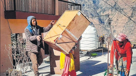 Local residents evacuate a building in Joshimath area of Uttarakhand’s Chamoli district on Tuesday. (PTI)