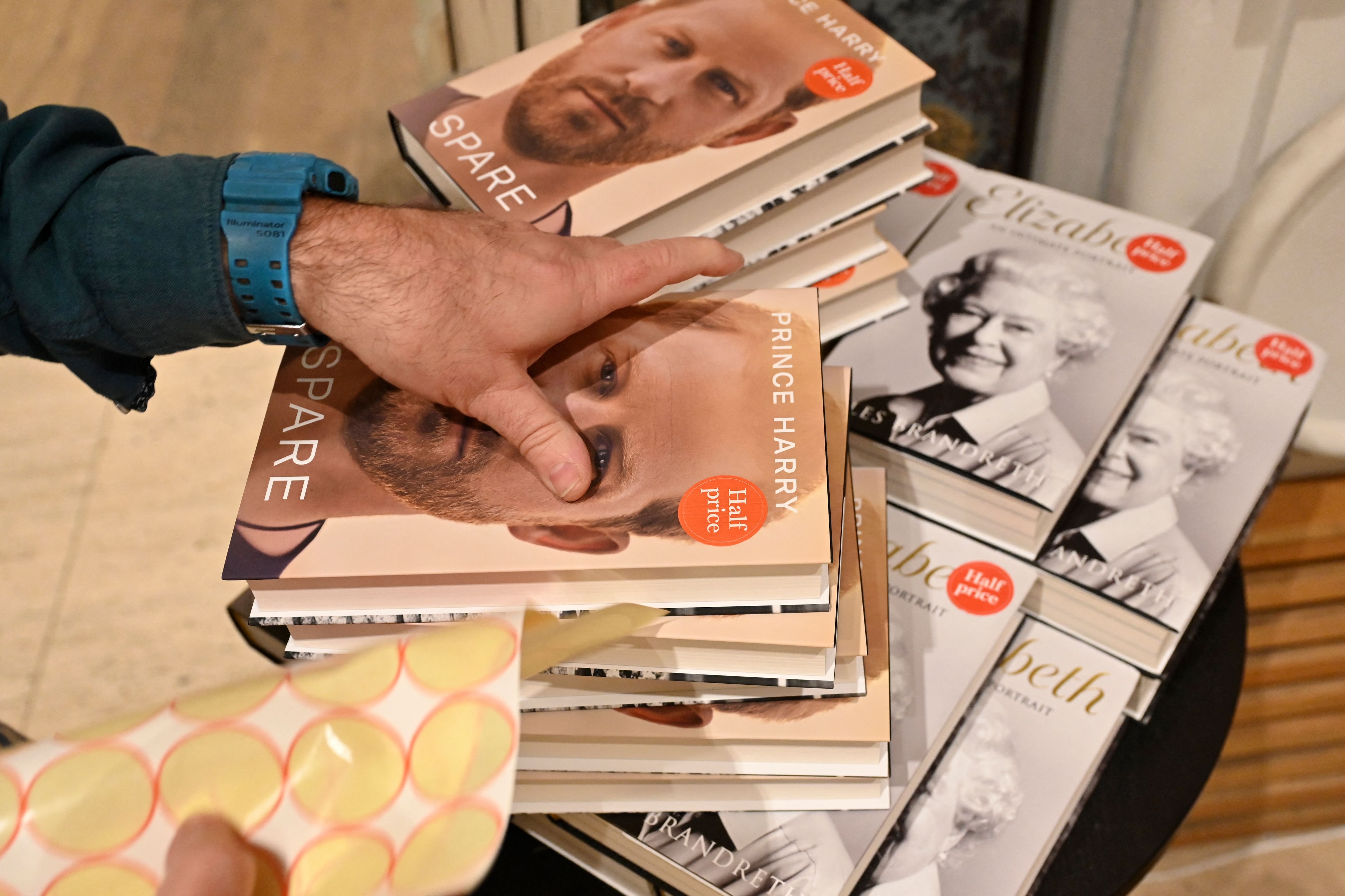 A bookseller puts a half price tag on copies of "Spare" by Britain's Prince Harry, Duke of Sussex. (AFP) A bookseller puts a half price tag on copies of "Spare" by Britain's Prince Harry, Duke of Sussex. (AFP)