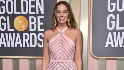 Margot Robbie makes a statement in a light pink gown featuring a halter neckline, intricate embroidery and a figure-skimming silhouette. A stylish brooch, open wavy locks, pink-hued makeup, and high heels rounded off her awards-show look. (Invision) Margot Robbie makes a statement in a light pink gown featuring a halter neckline, intricate embroidery and a figure-skimming silhouette. A stylish brooch, open wavy locks, pink-hued makeup, and high heels rounded off her awards-show look. (Invision)