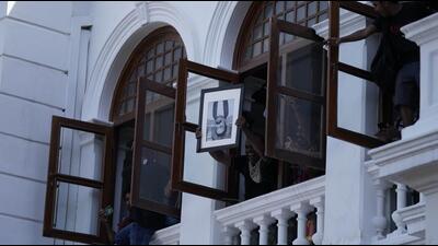 A protester holds a portrait of former Sri Lankan Prime Minister Mahinda Rajapaksa upside down after storming the office of Prime Minister Ranil Wickremesinghe, demanding he resign after Rajapaksa fled the country amid economic crisis in Colombo, Sri Lanka, on July 13, 2022. (AP)