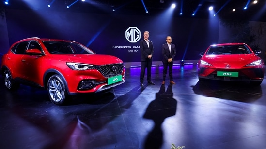 President and Managing Director of MG Motor India Private Limited Rajeev Chaba and Chief Commercial Officer MG Motor India Gaurav Gupta pose with MG EHS, Plug-in Hybrid and MG4 pure electric vehicle at the Auto Expo 2023 in Greater Noida on Wednesday. (REUTERS)