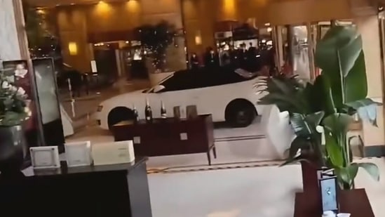 The car, a convertible with its top up, then hurtled haphazardly around the entrance hall.(Twitter/Byron_wan)