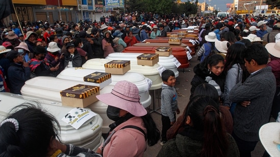 Relatives of 18 people killed in clashes with security forces wait with empty coffins outside the morgue of the Carlos Monge Medrano hospital in Juliaca, southern Peru, on January 10, 2023. (Photo by Juan Carlos CISNEROS/AFP)