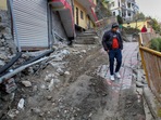 A man walks near damaged buildings in Joshimath. (PTI) A man walks near damaged buildings in Joshimath. (PTI)