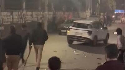 Police officers chase after the Hyundai Creta SUV as is speeds away from the spot after ramming into the PCR vehicle on Thursday. (HT Photo)