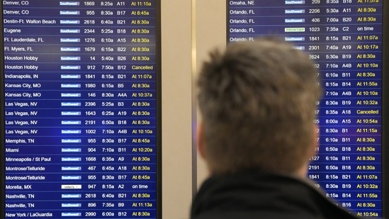 A passenger of Chicago looks at flight information screen at Chicago's Midway Airport that reflects the flight delays stemming from a computer outage at the Federal Aviation Administration on Wednesday, (AP)