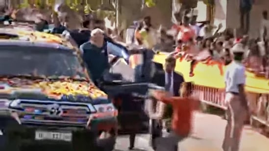 A youth tries to hand a garland to Prime Minister Narendra Modi while allegedly breaching his security cover during his roadshow in Hubballi on Thursday, (PTI)