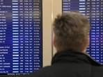 A passenger of Chicago looks at flight information screen at Chicago's Midway Airport that reflects the flight delays stemming from a computer outage at the Federal Aviation Administration on Wednesday, 