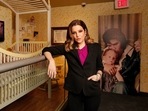 Lisa Marie Presley stands next to her childhood crib displayed with other mementos in an exhibit. (File Photo/ AP)