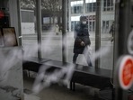 Covid In China: A commuter wearing a face mask walks past a closed shop in the central business district in Beijing.(AP) Covid In China: A commuter wearing a face mask walks past a closed shop in the central business district in Beijing.(AP)