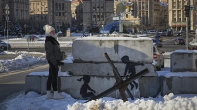 A woman stands next to a Banksy artwork in the main square in Kyiv, on December 1, 2022. In the conflict which began in February 2022, both sides have conceded heavy losses, with Moscow desperate to sell any win back home after repeated humiliations and Ukraine determined to hold -- and win back -- ground. (Efrem Lukatsky / AP) A woman stands next to a Banksy artwork in the main square in Kyiv, on December 1, 2022. In the conflict which began in February 2022, both sides have conceded heavy losses, with Moscow desperate to sell any win back home after repeated humiliations and Ukraine determined to hold -- and win back -- ground. (Efrem Lukatsky / AP)