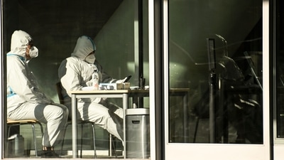 Covid In China: Security guards wearing personal protective equipment (PPE) amid the Covid-19 pandemic sit at an entrance of a building in Beijing. (AFP) Covid In China: Security guards wearing personal protective equipment (PPE) amid the Covid-19 pandemic sit at an entrance of a building in Beijing. (AFP)