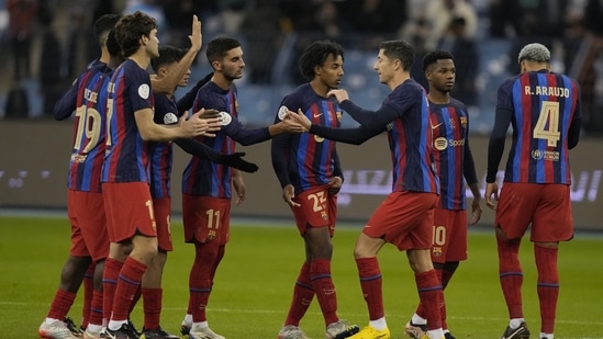 Barcelona's Robert Lewandowski, center, celebrates with his teammates after he scored his penalty kick during a semifinal soccer match in the Spanish Super Cup between Barcelona and Real Betis, in Riyadh, Saudi Arabia, Thursday, Jan. 12, 2023. (AP Photo/Hussein Malla).(AP)