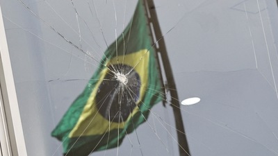 Brazil Anti-Democracy Riots: Brazil's flag is reflected on a broken window at Planalto Palace. (Reuters) Brazil Anti-Democracy Riots: Brazil's flag is reflected on a broken window at Planalto Palace. (Reuters)