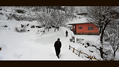 People walk on a snow-covered path on the outskirts of Srinagar on Saturday. (Waseem Andrabi /HT) People walk on a snow-covered path on the outskirts of Srinagar on Saturday. (Waseem Andrabi /HT)