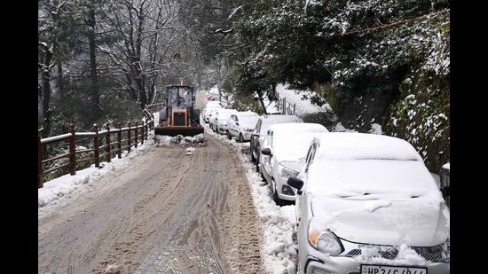 A land mover machine clears the snow from Sanjauli-IGMC hospital road after the fresh snowfall in Shimla on Saturday. (Deepak Sansta/HT)