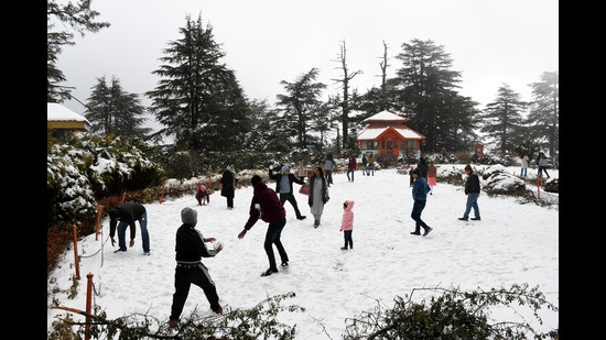 Tourists enjoying the snow at Jakhoo Temple after fresh snowfall in Shimla on Saturday. (Deepak Sansta/HT)