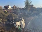 Locals watch the wreckage of a passenger plane as rescuers are scouring the crash site, in Pokhara, Nepal.(AP) Locals watch the wreckage of a passenger plane as rescuers are scouring the crash site, in Pokhara, Nepal.(AP)