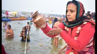 A woman praying to the Sun god after the dip in Sangam in the Magh Mela area on Sunday. (HT)