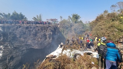 Crowds gather as rescue teams work to retrieve bodies at the crash site (via REUTERS)