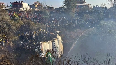 Locals watch the wreckage of a passenger plane as rescuers are scouring the crash site, in Pokhara, Nepal. (AP) Locals watch the wreckage of a passenger plane as rescuers are scouring the crash site, in Pokhara, Nepal. (AP)
