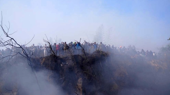 Nepal plane crash: Locals watch the wreckage of a passenger plane in Pokhara, Nepal.(AP)