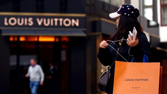 A woman with a Louis Vuitton-branded shopping bag.(Reuters)