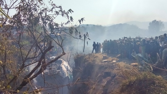 Crowds gather at the crash site of an aircraft carrying 72 people in Pokhara in western Nepal January 15, 2023.(via Reuters)