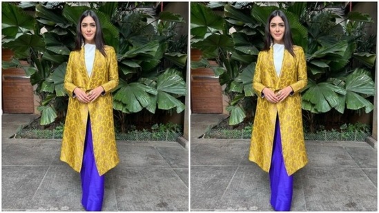 Mrunal wore a white top, and layered it with a yellow satin overcoat with full sleeves, and silver embroidery work. She added more colours to her look with a pair of bright blue satin palazzos.&nbsp;(Instagram/@mrunalthakur)