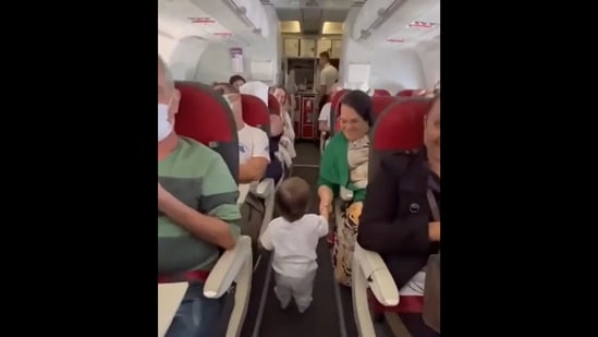 Toddler shaking hands with passengers he meets aboard a flight. (Twitter/@MorissaSchwartz)