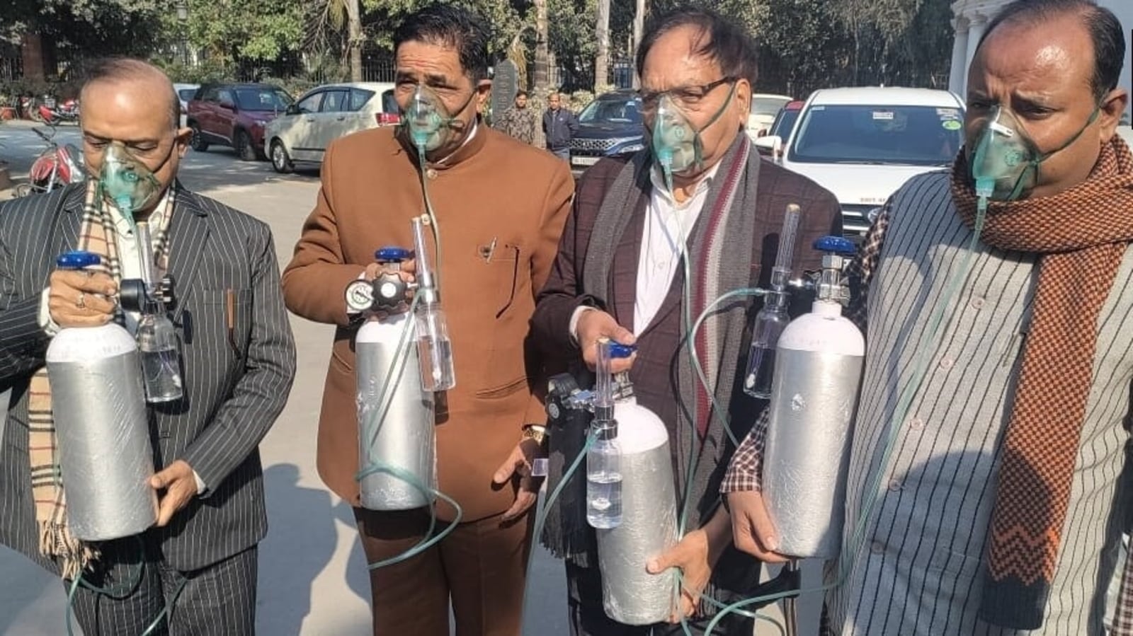 Delhi BJP MLAs carry oxygen cylinders wearing gas masks to assembly
