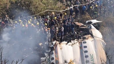 Nepalese rescue workers and civilians gather around the wreckage of a passenger plane that crashed in Pokhara, Nepal, Sunday, Jan. 15, 2023. (AP Photo/Krishna Mani Baral)