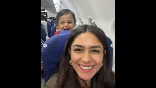 Mrunal Thakur is taking a selfie with a cute fellow passenger sitting behind her aboard the IndiGo flight. (Instagram/@mrunalthakur)