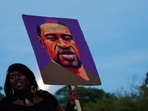 A woman holds a placard depicting George Floyd during a demonstration on the first anniversary of his death, in Brooklyn, New York City, New York, US.