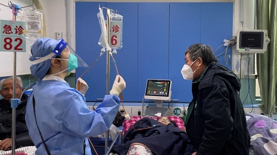 World Health Organisation On Covid: A medical worker checks the IV drip treatment of a patient lying on a bed in the emergency department of a hospital, amid the coronavirus disease (COVID-19) outbreak in Shanghai, China.(Reuters)