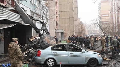 Military and onlookers stand at the site where a helicopter crashed near a kindergarten. (AFP)