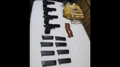 The four China-made pistols and ammunition recovered from a packet dropped by a Pakistani drone near Uncha Takala village along the India-Pakistan border in Gurdaspur district late on Tuesday night. (HT Photo)