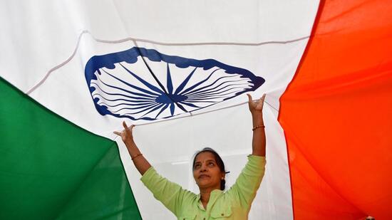 Workers give finishing touches to an Indian flag at a workshop ahead of the Republic Day, in Mumbai on Wednesday. (HT PHOTO)