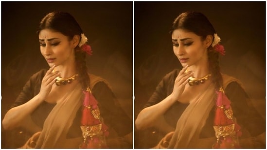 Mouni wore her tresses in a clean braid and added rose and flowers to her hair. She also added more ethnic vibes to her look with pink pompom and golden zari details to her braid.&nbsp;(Instagram/@imouniroy)