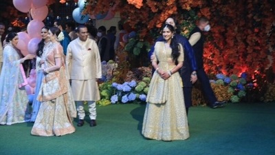 Radhika looked every bit gorgeous in a golden embellished lehenga, while Anant complemented her in a contrasting navy blue set of kurta and pajamas.&nbsp; (Hindustan Times)