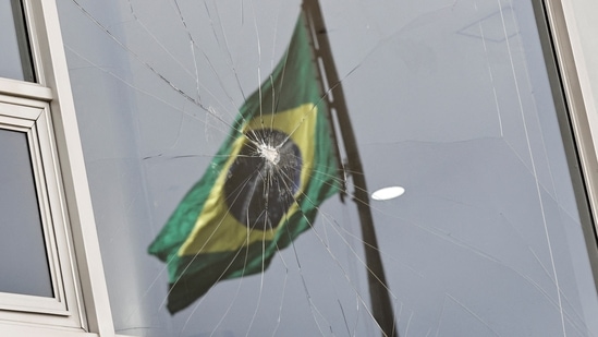 Brazil Riots: Brazil's flag is reflected on a broken window at Planalto Palace.(Reuters)