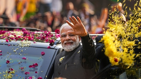 Prime Minister Narendra Modi waves at supporters during a roadshow in New Delhi(PTI file)