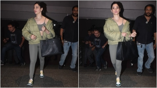 In the end, Tamannaah chose a light green puffer jacket featuring an open zipper front, wide collars and full-length sleeves to complete the airport look. A sleek low bun, a large black tote bag from Louis Vuitton, multi-coloured sneakers, pink lip shade, blushed glowing skin and kajal rounded it all off.&nbsp;(HT Photo/Varinder Chawla)