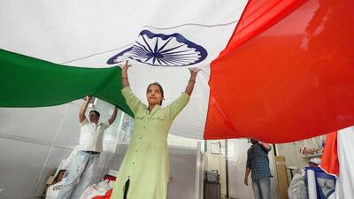 People hold a massive Tricolour at a shop ahead of the Republic Day celebrations. (PTI Photo) People hold a massive Tricolour at a shop ahead of the Republic Day celebrations. (PTI Photo)